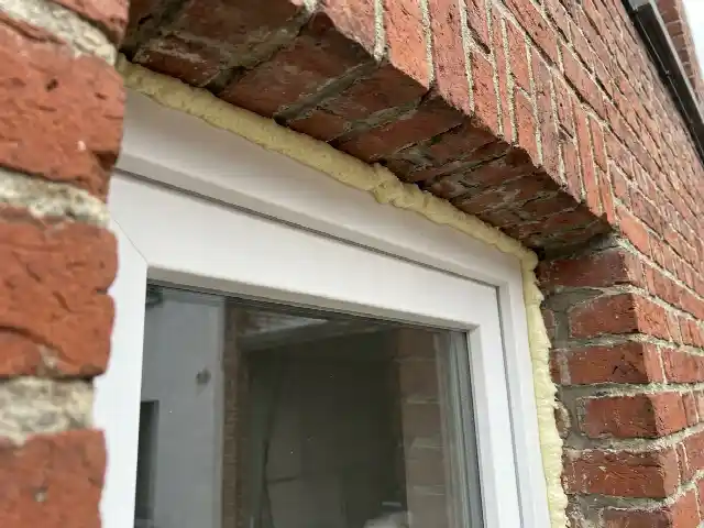 Nouveau châssis PVC logé derrière la battée d'une façade en briques